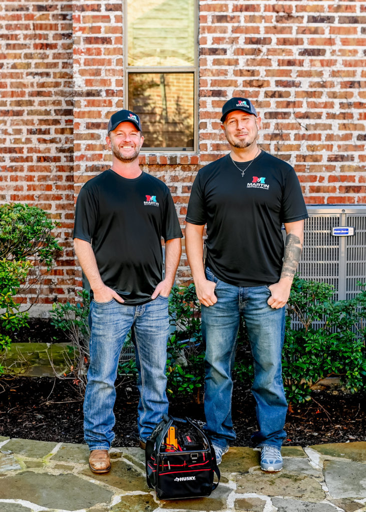 Martin Heating & Air air conditioning and heating technicians standing in front of a home